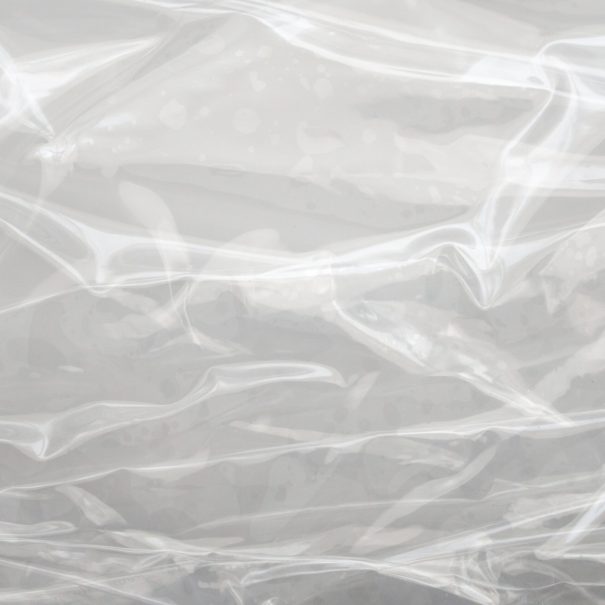 A close-up view of clear, crinkled plastic sheeting with visible folds and creases.