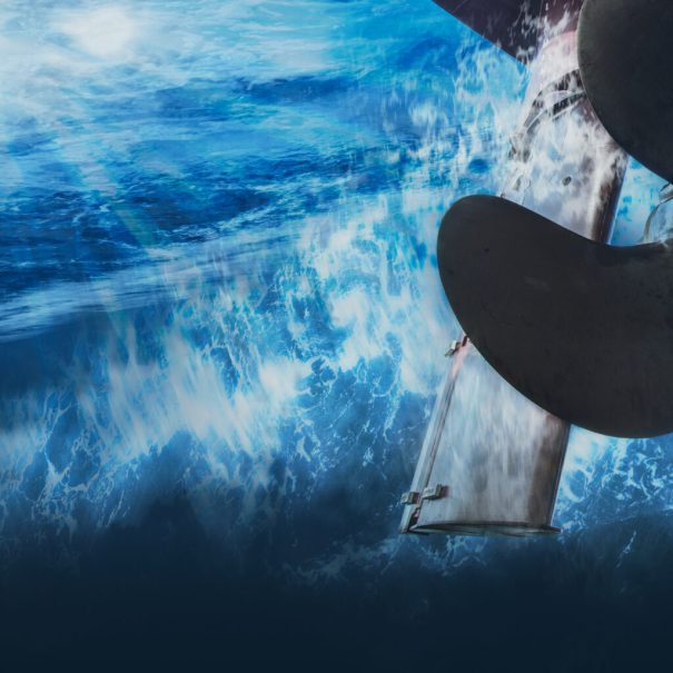 Underwater view of a ship’s propeller and rudder near the water’s surface, with light filtering through the waves above—ideal for powering prediction analysis and tank testing studies.